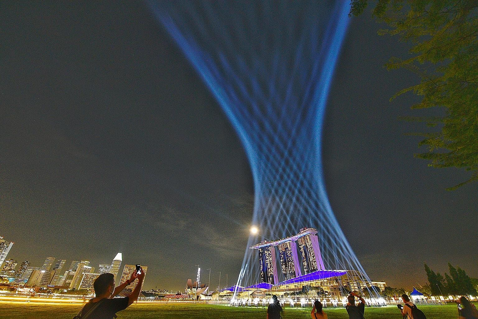 Visitors at the Shine a Light display at The Promontory yesterday, with Marina Bay Sands in the background. The display is part of the year-end celebrations, which are expected to be muted, given the Covid-19 pandemic. The light display is created by