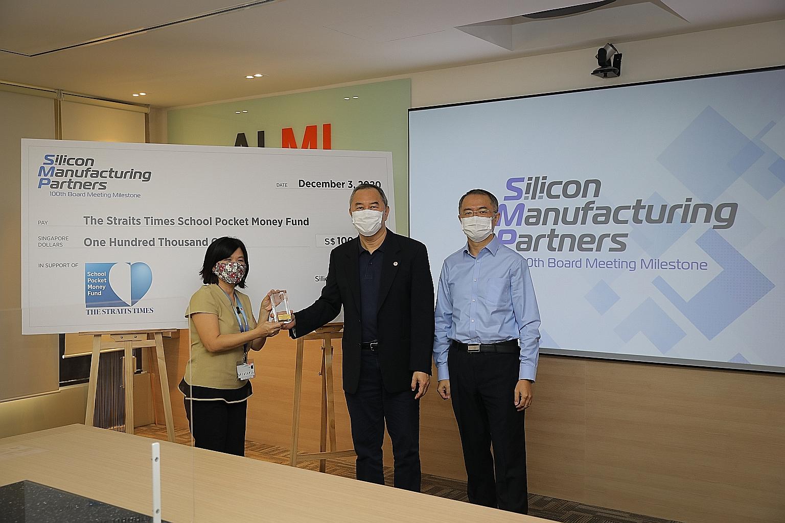 The Straits Times School Pocket Money Fund general manager Tan Bee Heong (left) giving a token of appreciation to Silicon Manufacturing Partners (SMP) chairman Ang Kay Chai for the company's donation to the fund yesterday. Next to Mr Ang is SMP gener