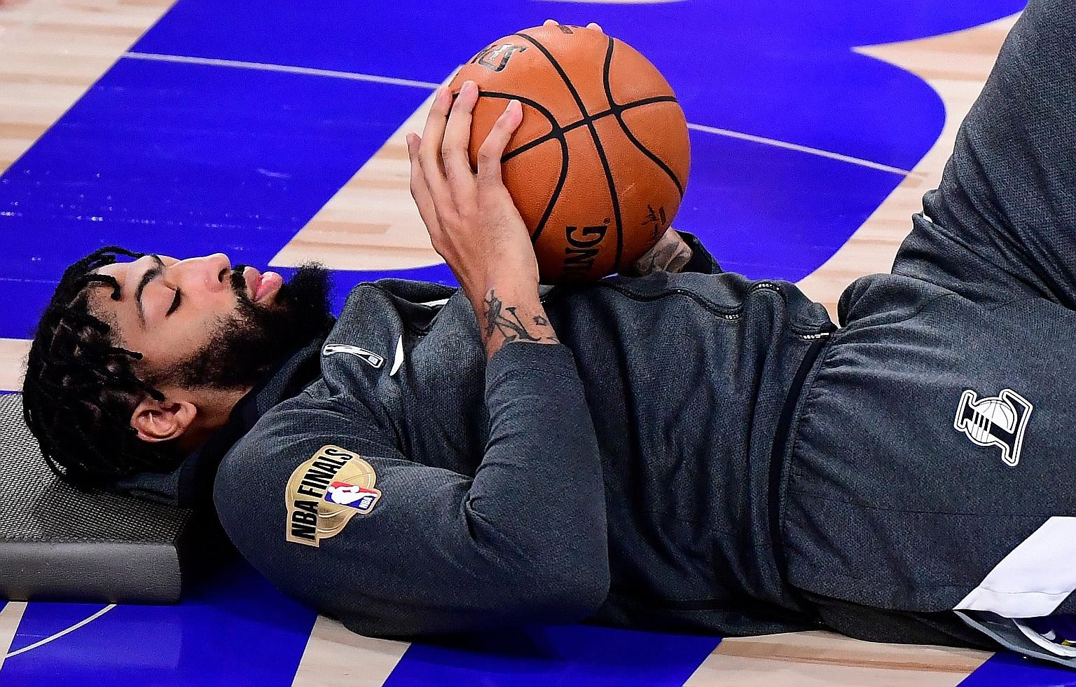 Anthony Davis stretching before the LA Lakers' Game 6 victory over the Miami Heat in October's NBA Finals to seal a record-tying 17th title. He expects the team to use him and LeBron James less in the early part of the new season to give them more re