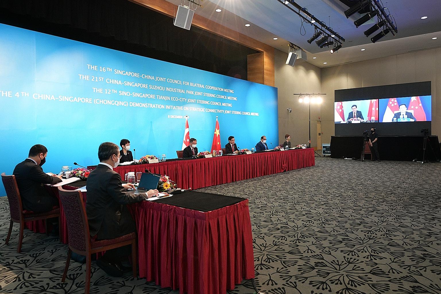 Deputy Prime Minister Heng Swee Keat co-chairing the meetings yesterday with Chinese Vice-Premier Han Zheng (on screen). With Mr Heng are (facing the camera, from left) Minister for Sustainability and the Environment Grace Fu, Health Minister Gan Kim