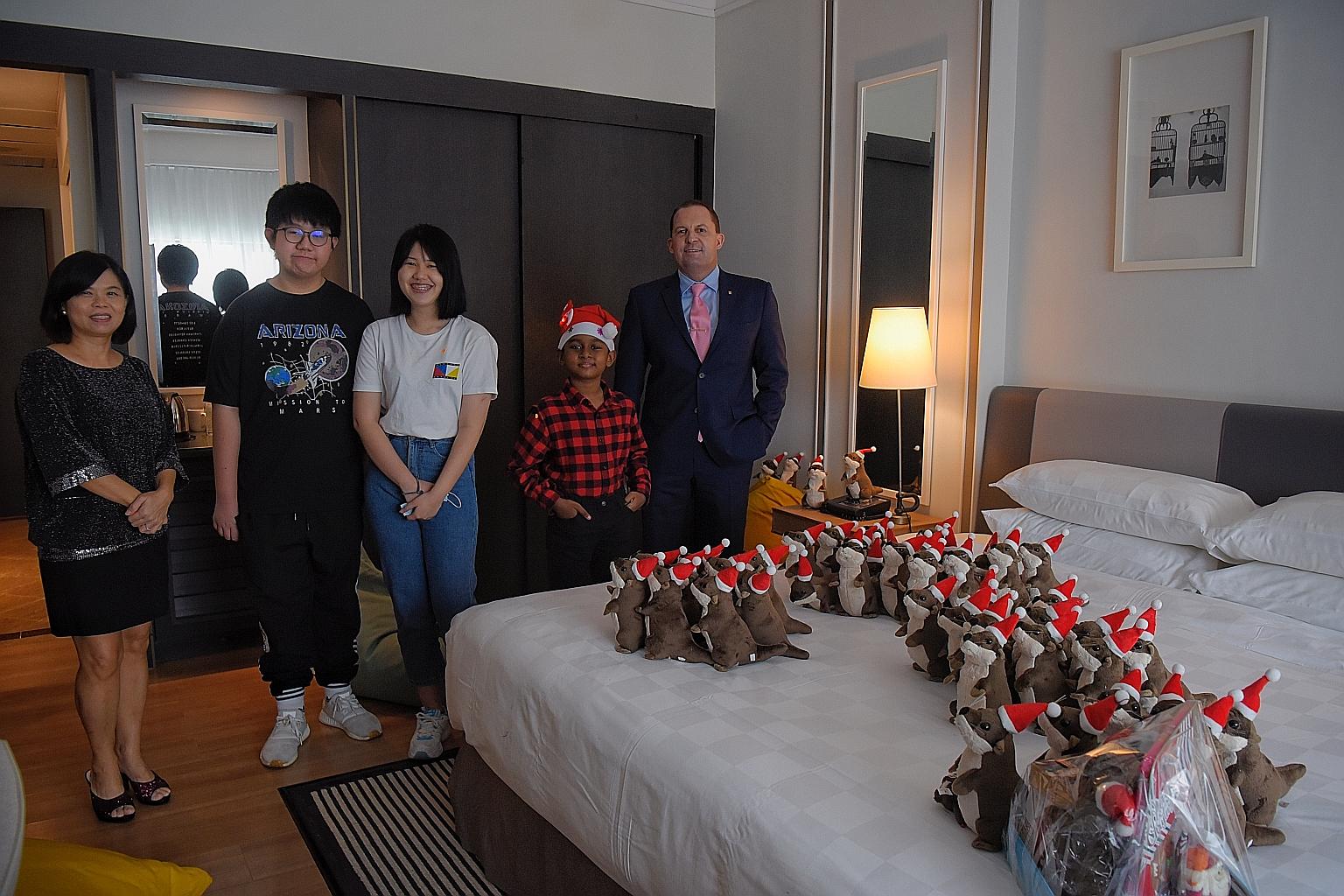 STSPMF general manager Tan Bee Heong and Millennium Hotels and Resorts vice-president of operations (SEA) Lee Richards with beneficiaries Loh Miao Xin (centre), 18; her brother Khim San, 13; and S. Mugunthesh, nine, at Orchard Hotel yesterday, where