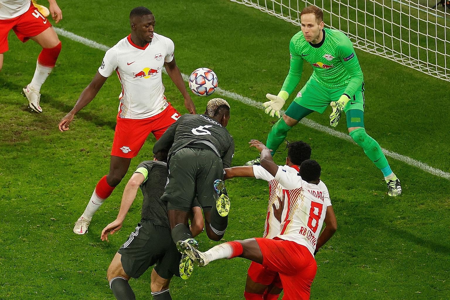 Man United substitute Paul Pogba (No. 6) leaping the highest to head the ball towards goal, forcing an own goal off Leipzig's Ibrahima Konate. Nevertheless, it was too little too late, as the English side crashed out of the Champions League after the