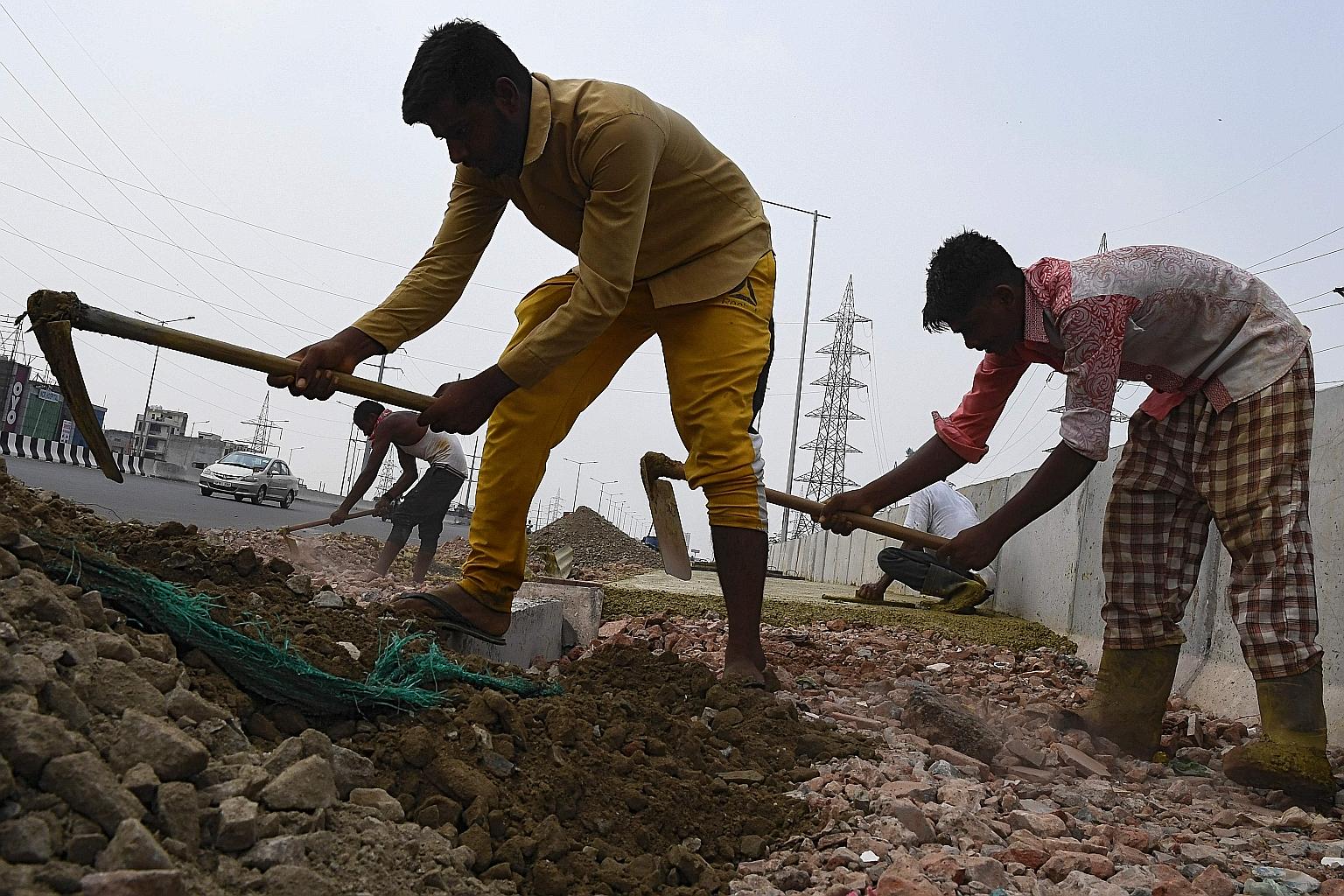 Labourers working on a highway in Ghaziabad, in the Indian state of Uttar Pradesh. The Asian Development Bank has lifted India's economic growth projection to minus 8 per cent, from minus 9 per cent previously expected. Next year, India's economy is 