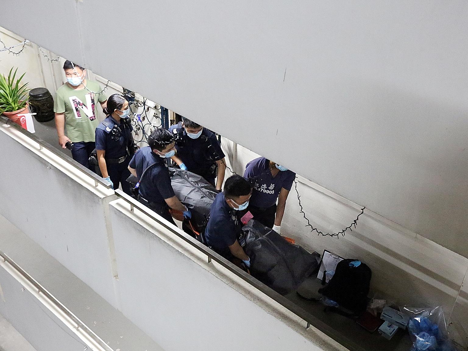 The bodies being removed from the flat in Ho Ching Road on Thursday. Police were alerted to the unnatural deaths at about 4.15pm that day.