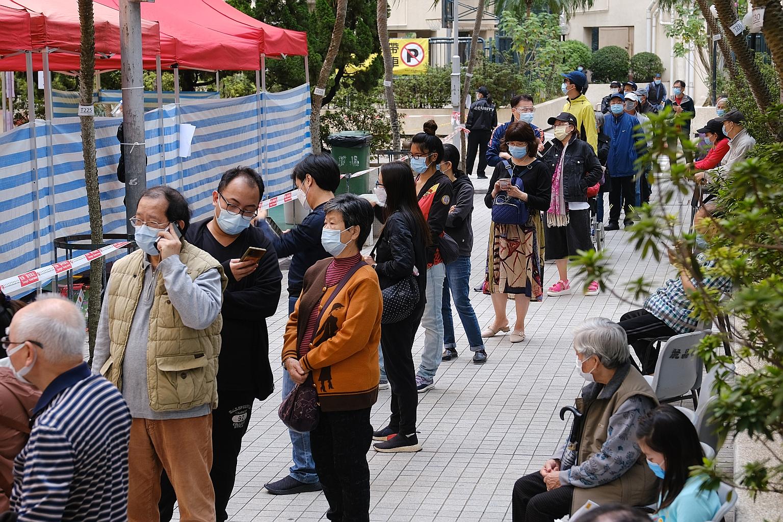 Residents queueing on Thursday at a Covid-19 testing centre set up at a housing estate in Hong Kong's Kowloon Bay area. Singapore will be tightening border measures due to the worsening virus situation in Hong Kong. PHOTO: BLOOMBERG