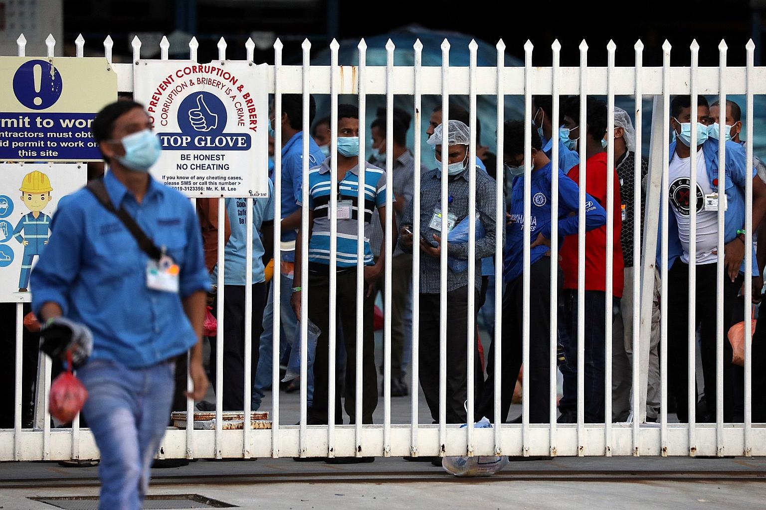 Workers queueing to leave a Top Glove factory in Klang after their shift last week. The glove maker's complex of factories and dormitories in Klang has become Malaysia's largest Covid-19 cluster with over 5,000 infections. An employee had taken two p
