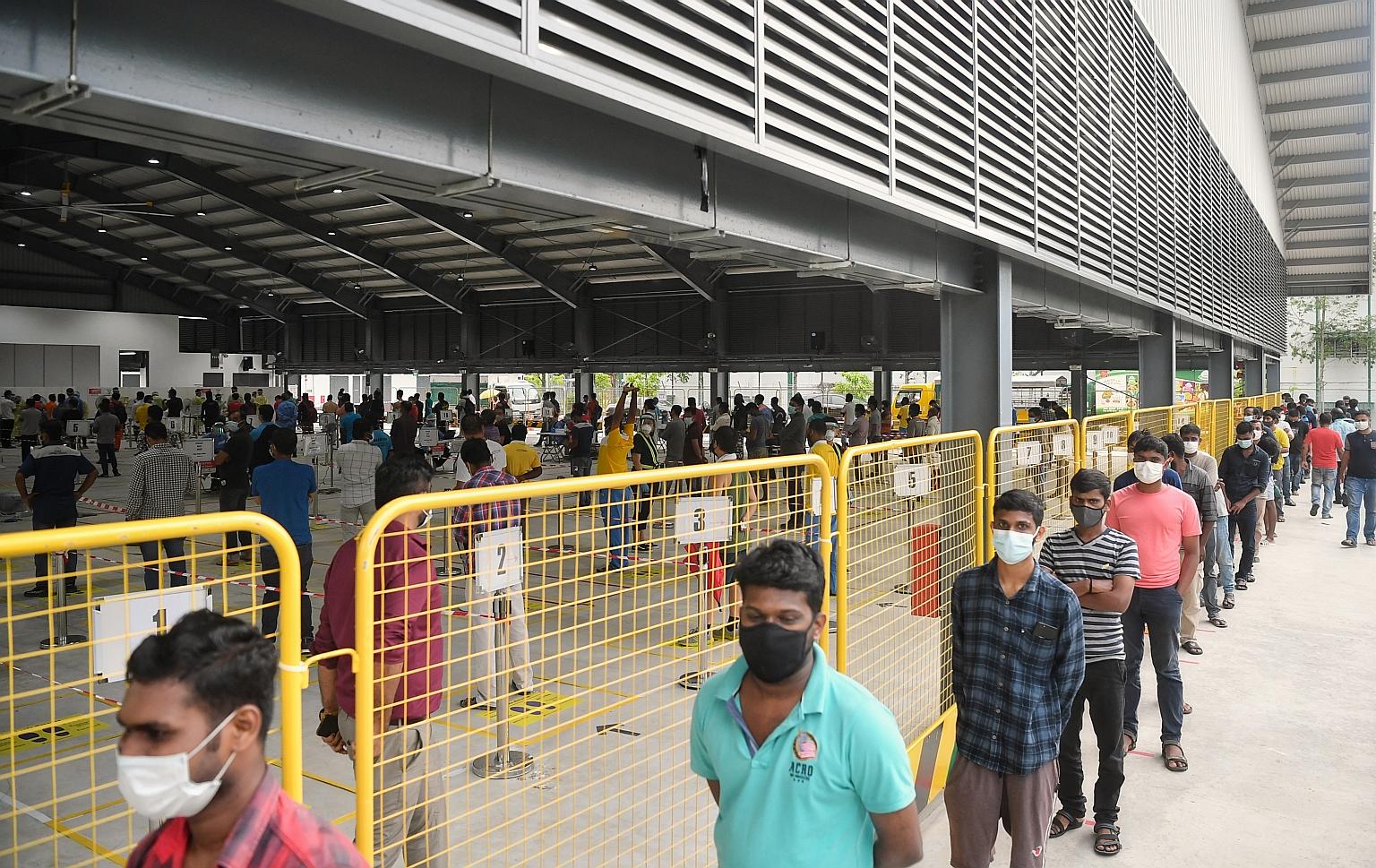 Migrant workers queueing to have a Covid-19 swab test at a regional screening centre in Sembawang in October. Second Minister for Manpower Tan See Leng said that by August, all migrant workers staying in dormitories had been tested at least once for