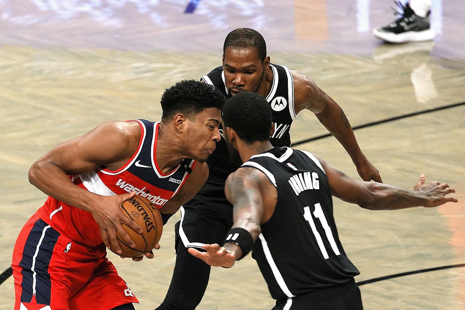Brooklyn duo Kyrie Irving and Kevin Durant double-teaming Washington's Rui Hachimura. The two were playing together for the first time since signing for the Nets last year.