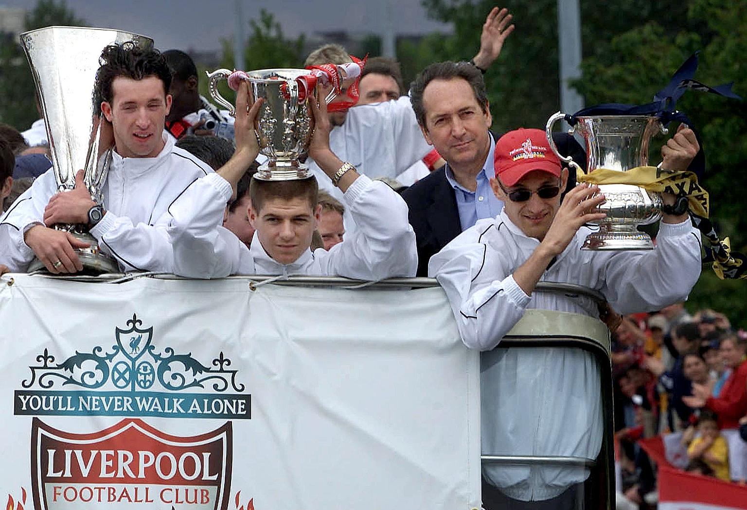 Gerard Houllier, flanked by (from right) Sami Hyypia, Steven Gerrard and Robbie Fowler, his three captains at Liverpool each holding a trophy from their 2000-01 season during a parade of the city. The Frenchman was Liverpool's first non-British manag