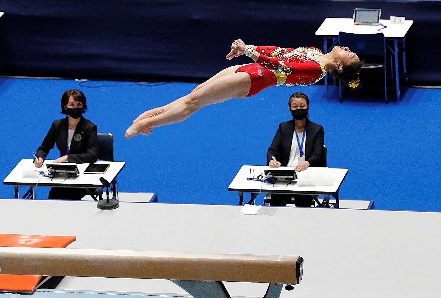 Judges scoring China gymnast Zhou Ruiyu's performance on the balance beam at a recent competition in Tokyo, one of several events held to test Tokyo Olympics' coronavirus protocols.