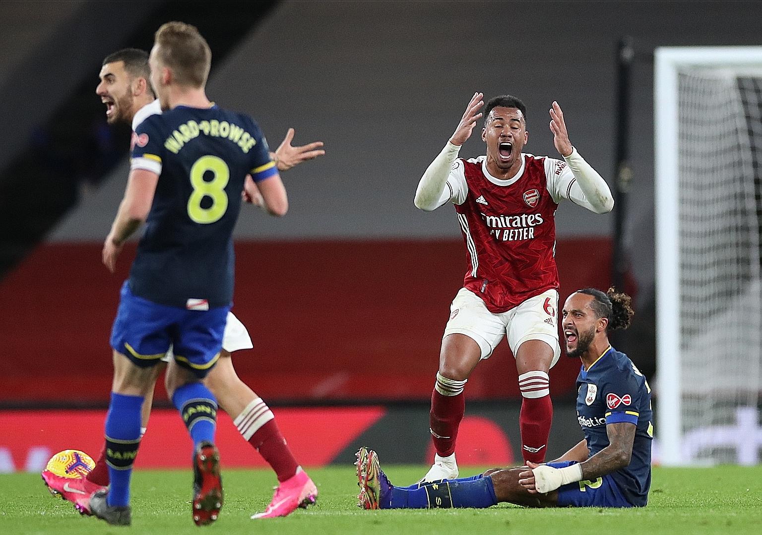 Gabriel pleading his innocence unsuccessfully after fouling the Saints' Theo Walcott. The Arsenal defender was sent off for his troubles.