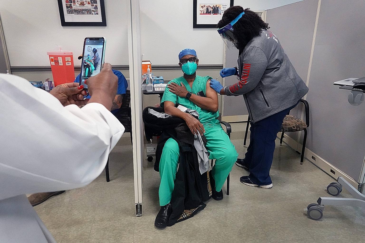 A doctor getting vaccinated at a hospital in Chicago amid a massive roll-out of the Covid-19 vaccine from Pfizer-BioNTech in the US last week. PHOTO: AGENCE FRANCE-PRESSE