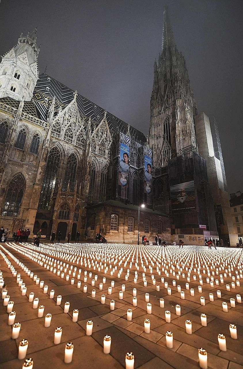 People lighting candles to commemorate the victims of the coronavirus pandemic at the Stephansplatz square in Vienna, Austria, last Friday. The writer says that beyond fear and isolation, maybe this is what the pandemic holds for us: the understandin