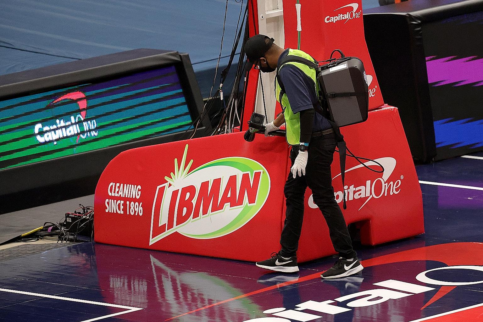 A worker disinfecting the base of the basket before the start of the Washington Wizards v Detroit Pistons pre-season game at Capital One Arena in Washington DC.