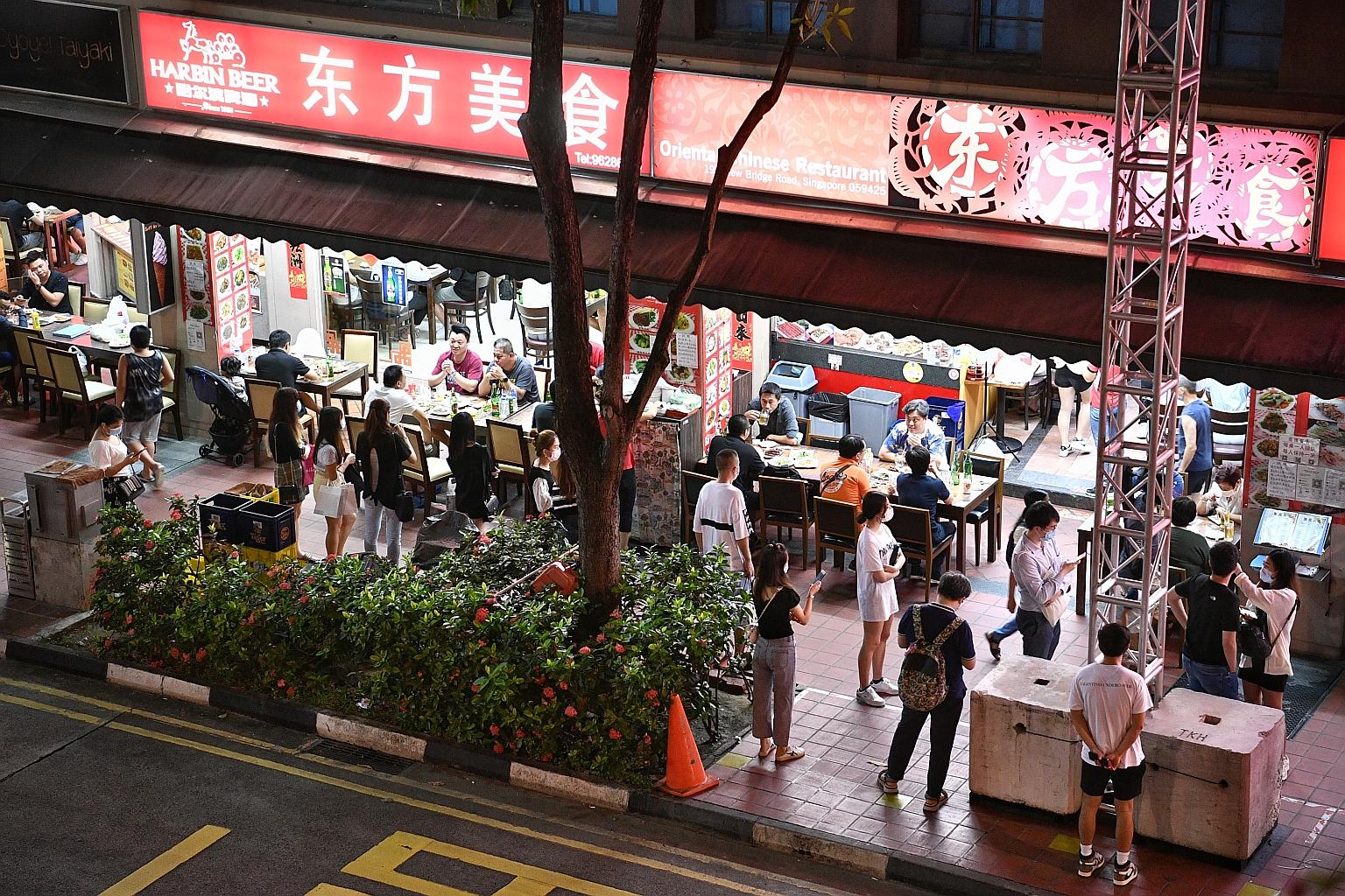 People queueing outside a restaurant at the junction of New Bridge Road and Mosque Street on Saturday. The Ministry of Sustainability and the Environment has said there will be more checks on F&B outlets to ensure safe management measures are being c