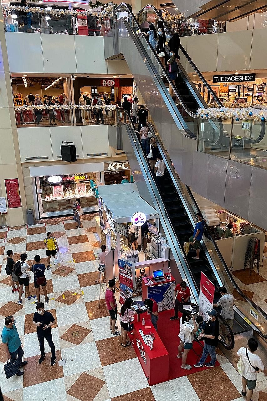 Above: Shoppers at West Mall yesterday, on the final weekend before Christmas. ST PHOTO: CHONG JUN LIANG Right: VivoCity on Saturday, where regular announcements reminded people to keep a safe distance. ST PHOTO: GIN TAY Below: Social distancing amba