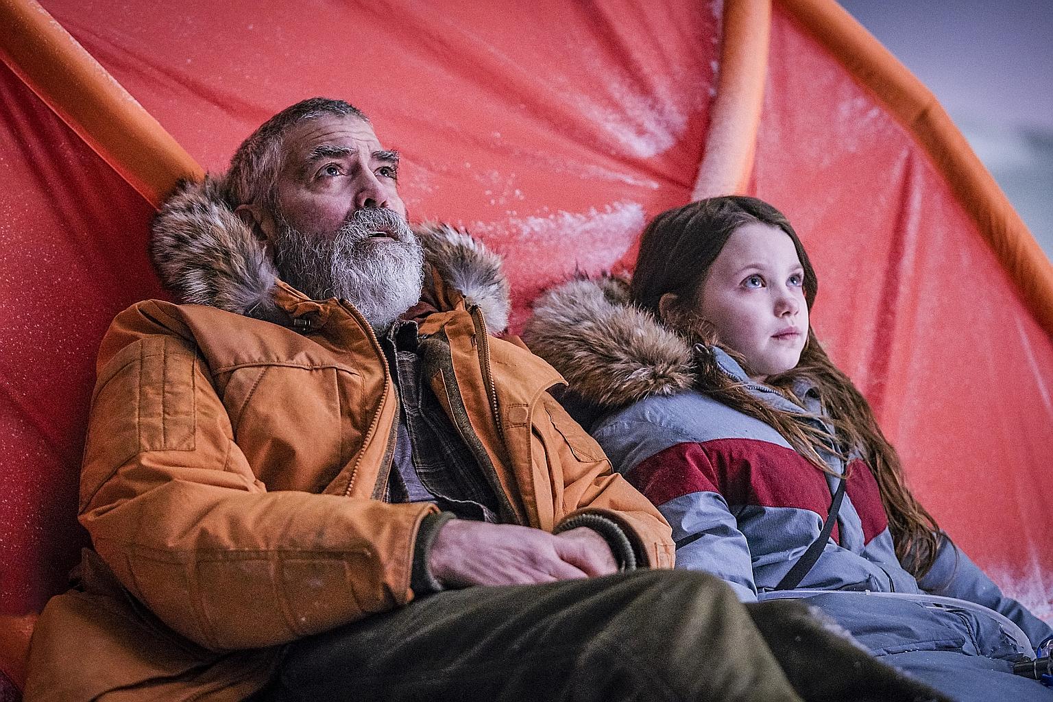 George Clooney and Caoilinn Springall (both left) star in The Midnight Sky as a scientist and mysterious child who appear to be the only ones left on Earth after a disaster.