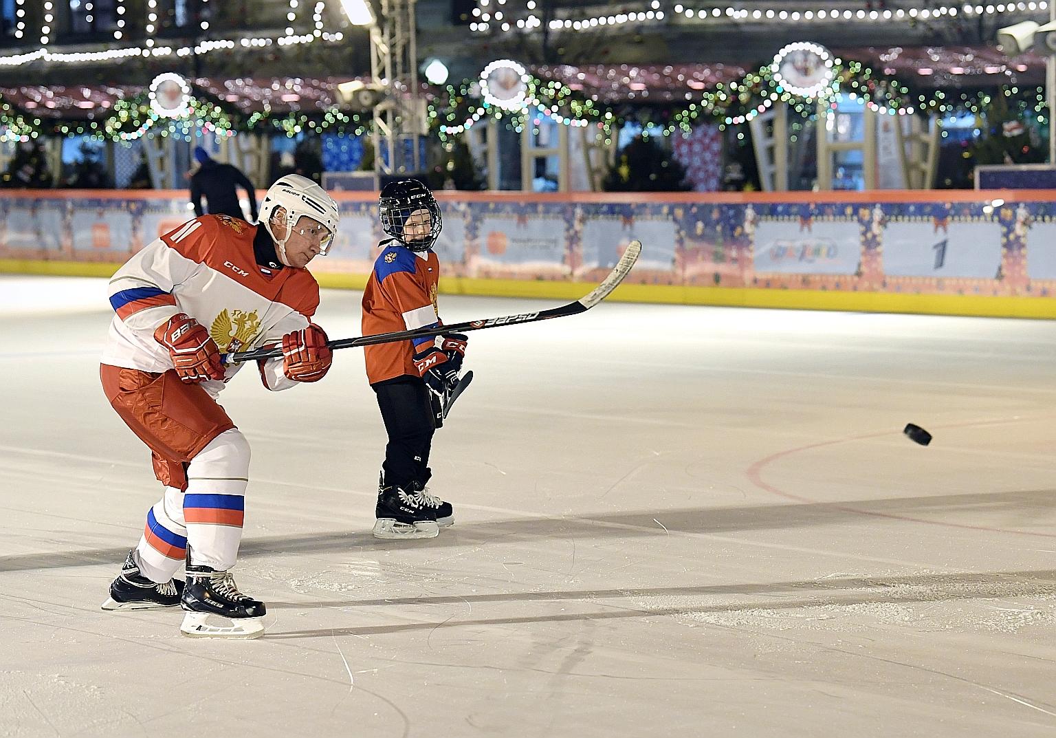 Russian President Vladimir Putin playing hockey with Dmitry Ashchepkov, a nine-year-old boy from Chelyabinsk who had said it was his dream, at the ice rink on Red Square in Moscow yesterday. The training was conducted by the Olympic champion, three-t
