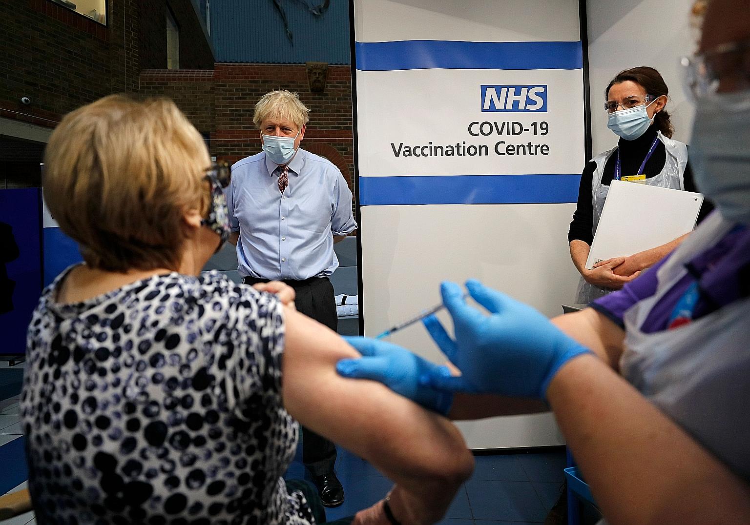 Prime Minister Boris Johnson watching a woman getting the Pfizer-BioNTech Covid-19 vaccine in London on Dec 8. As Britain struggles to contain a rapid surge in Covid-19 cases, National Health Service leaders said a month's extension of the Brexit tra