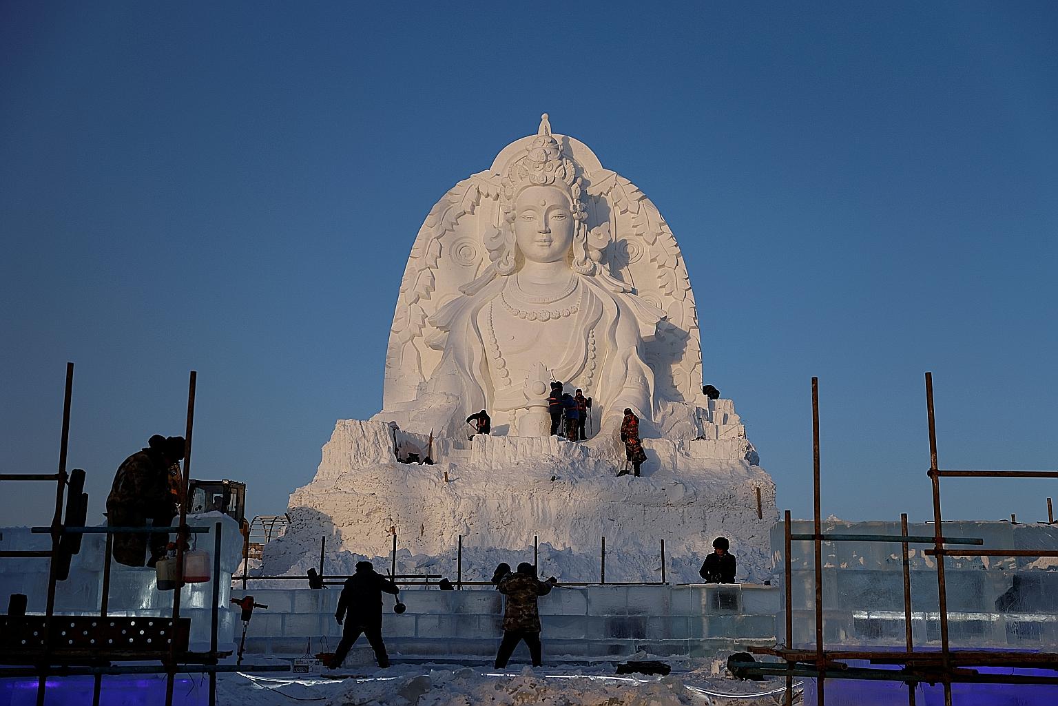 Workers preparing a giant Buddha snow sculpture at the site of the 37th Harbin International Ice and Snow Sculpture Festival before its opening on Jan 5. PHOTO: REUTERS