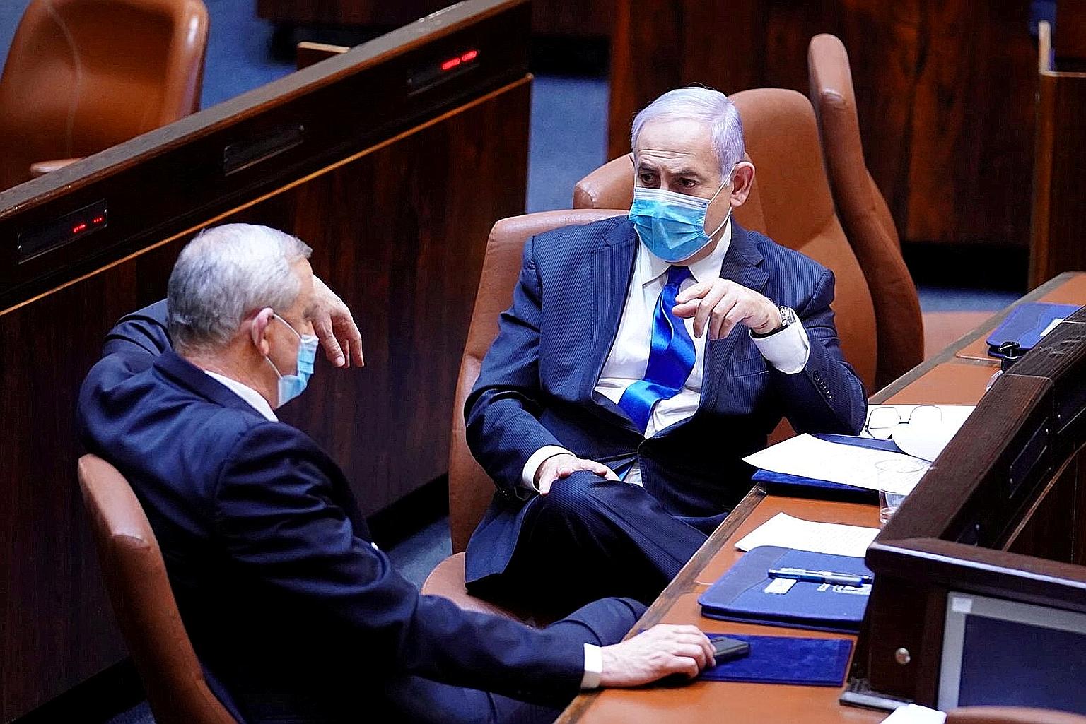 Israeli Prime Minister Benjamin Netanyahu (facing camera), of the conservative Likud party, and his rival-turned-partner Benny Gantz, of the centrist Blue and White party, in Parliament in May. They blame each other for the crisis. PHOTO: REUTERS