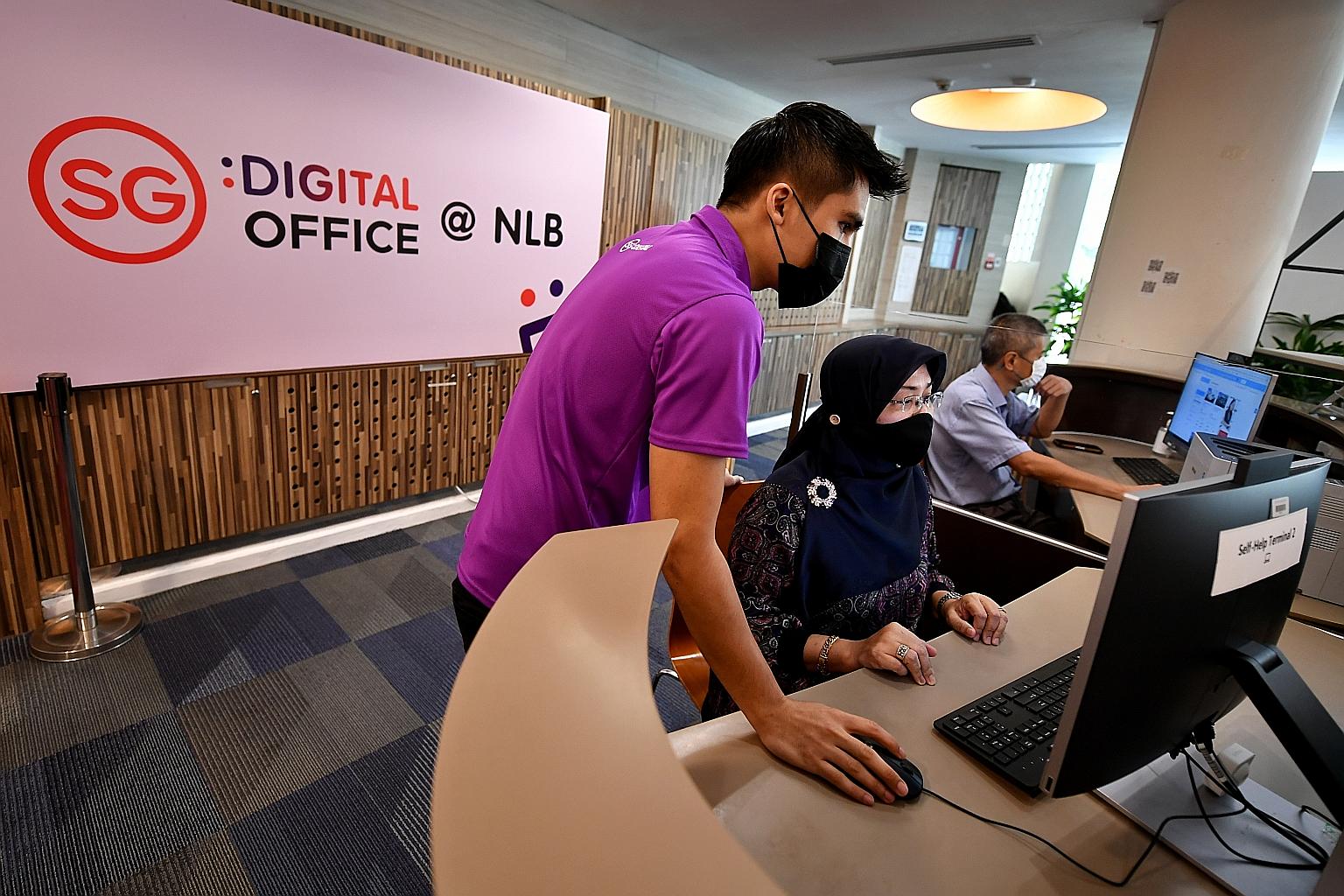 Public service ambassador Danial Hariz Sazaly, guiding Madam Siti Hajar, a retiree, through the government digital services at the SG Digital Office in Geylang East Public Library yesterday. This is a pilot programme which started early last month. S