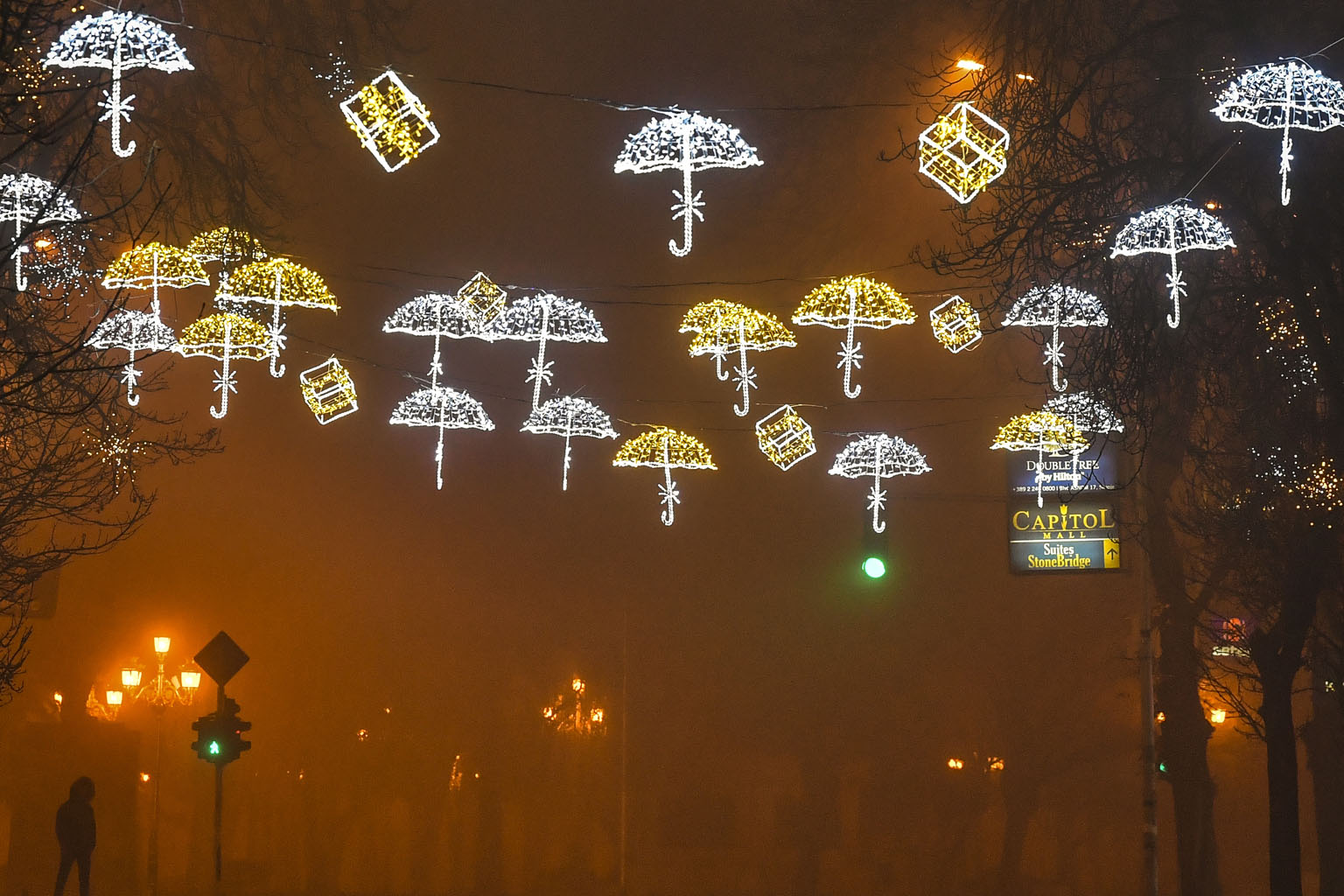 A man walking through an empty, decorated street during heavy fog and air pollution that covered Skopje valley in Skopje, the Republic of North Macedonia, yesterday. Fog, smog, increased emissions on account of household heating requirements and othe