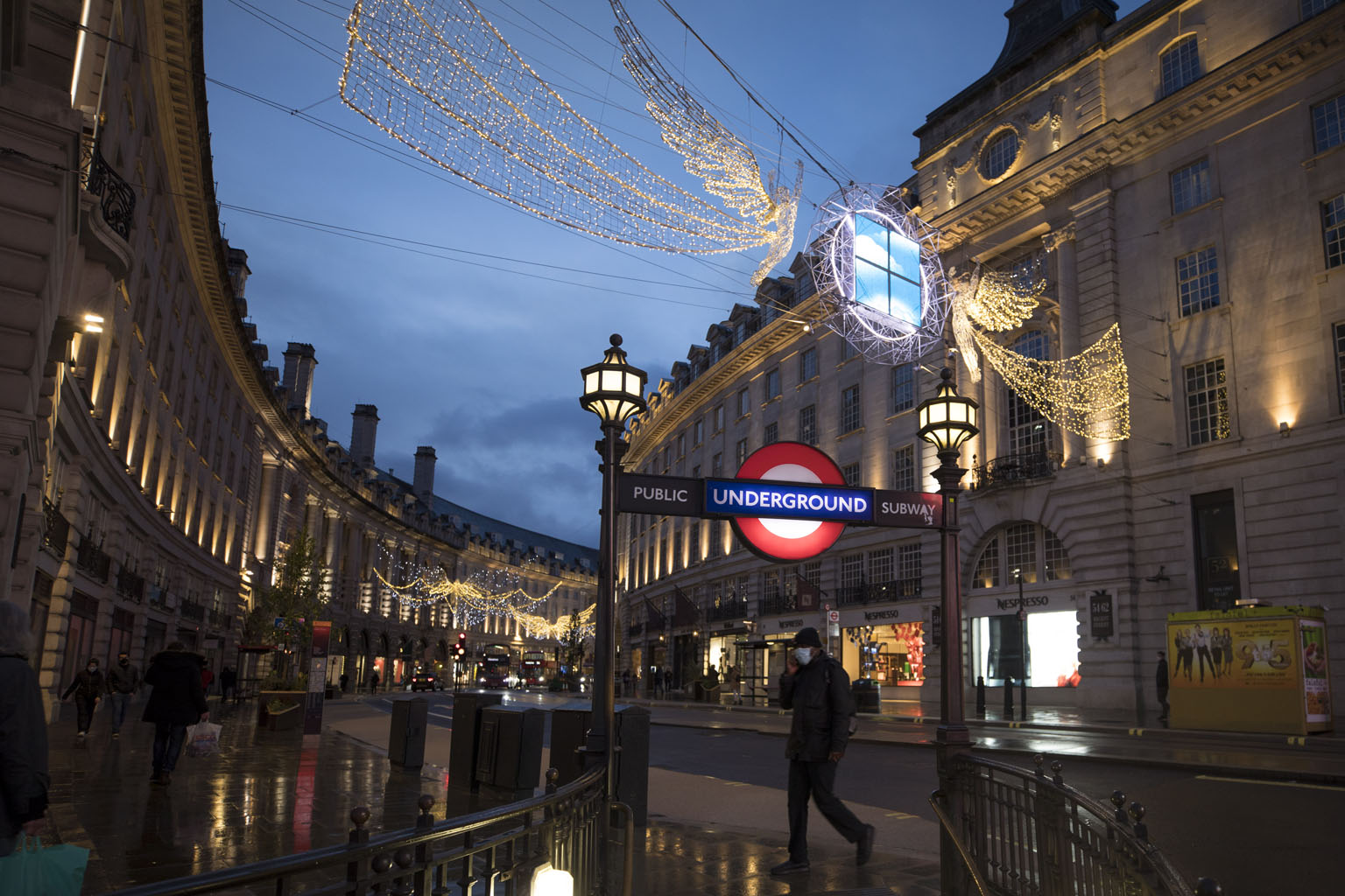 A pedestrian entering the London Underground on a nearly deserted Regent Street on Wednesday. Prime Minister Boris Johnson has imposed tougher regulations across a large swathe of England to tackle a new strain of the coronavirus which emerged in Sep
