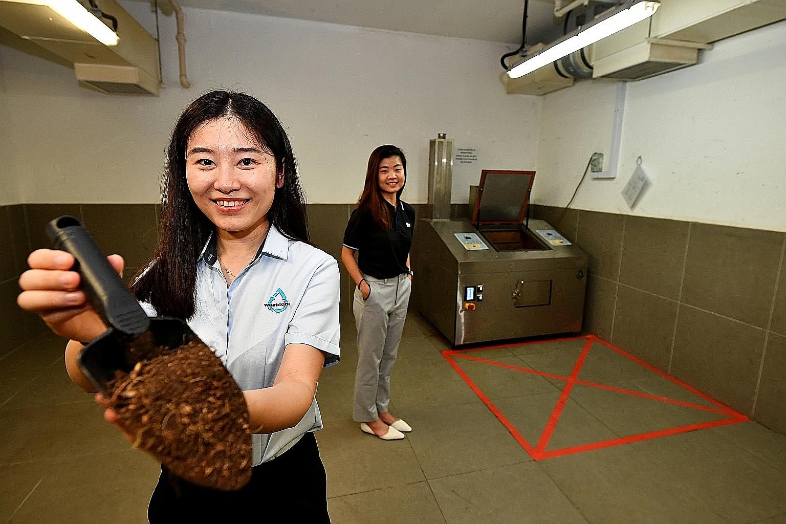 Ms Chua Kai-Ning, chief marketing director of Insectta, with a handful of pupae inside the mating chamber that houses one million black soldier flies. ST PHOTOS: LIM YAOHUI Ms Yeo Pei Shan, co-founder of UglyFood, with the rejected blemished fruit an
