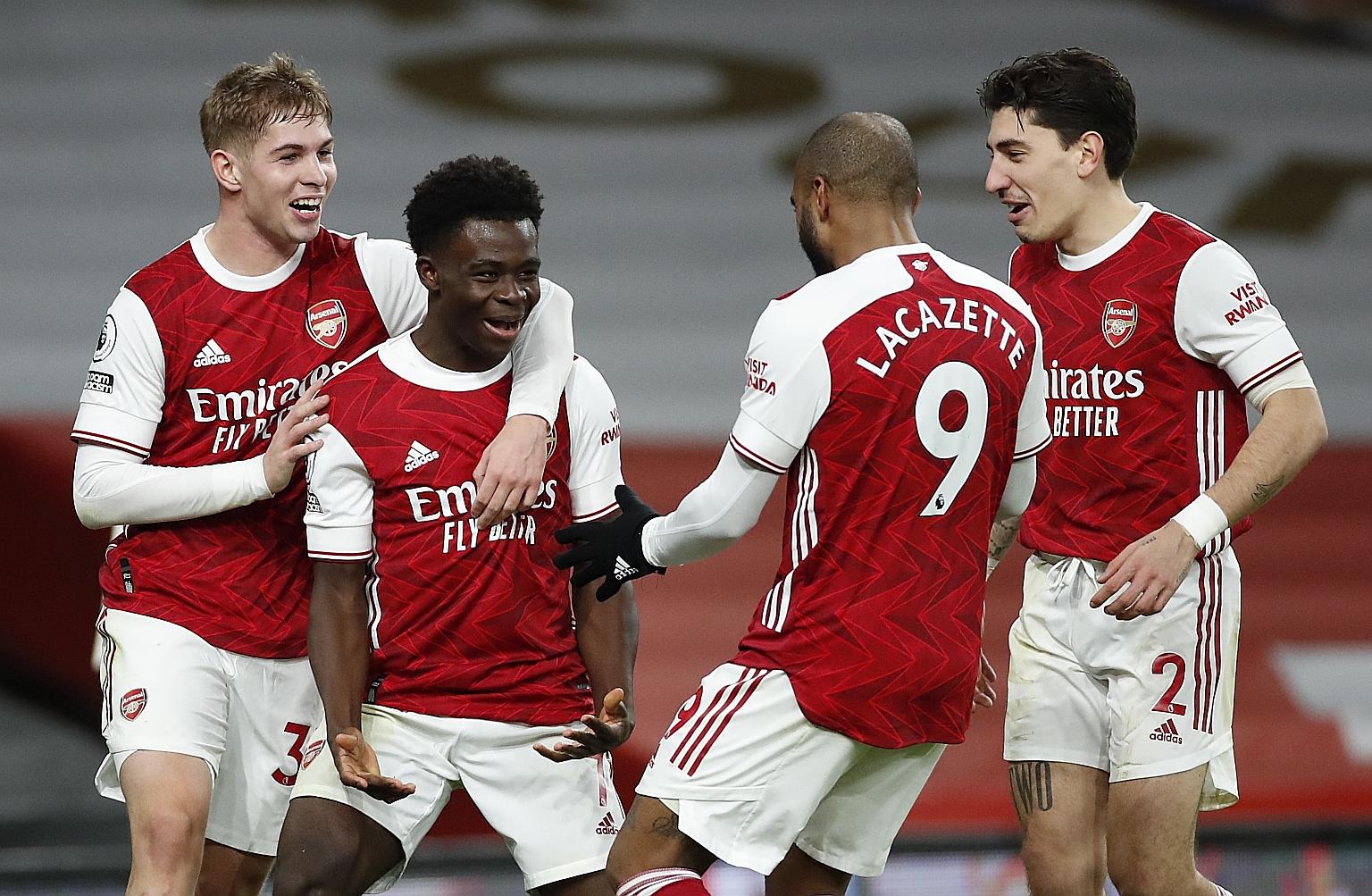 Midfielder Bukayo Saka celebrating with (from far left) Emile Smith Rowe, Alexandre Lacazette and Hector Bellerin after scoring the Gunners' third goal in their 3-1 win over Chelsea.