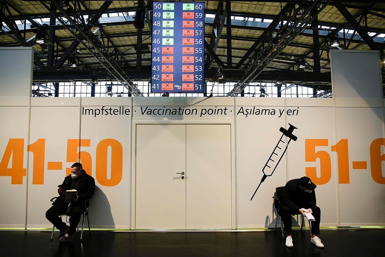 Two men waiting to get their Covid-19 vaccine jabs at a vaccine centre in Berlin on Sunday. Several German cities faced delays in vaccination after temperature trackers showed about 1,000 of the shots made by BioNTech and Pfizer might not have been k