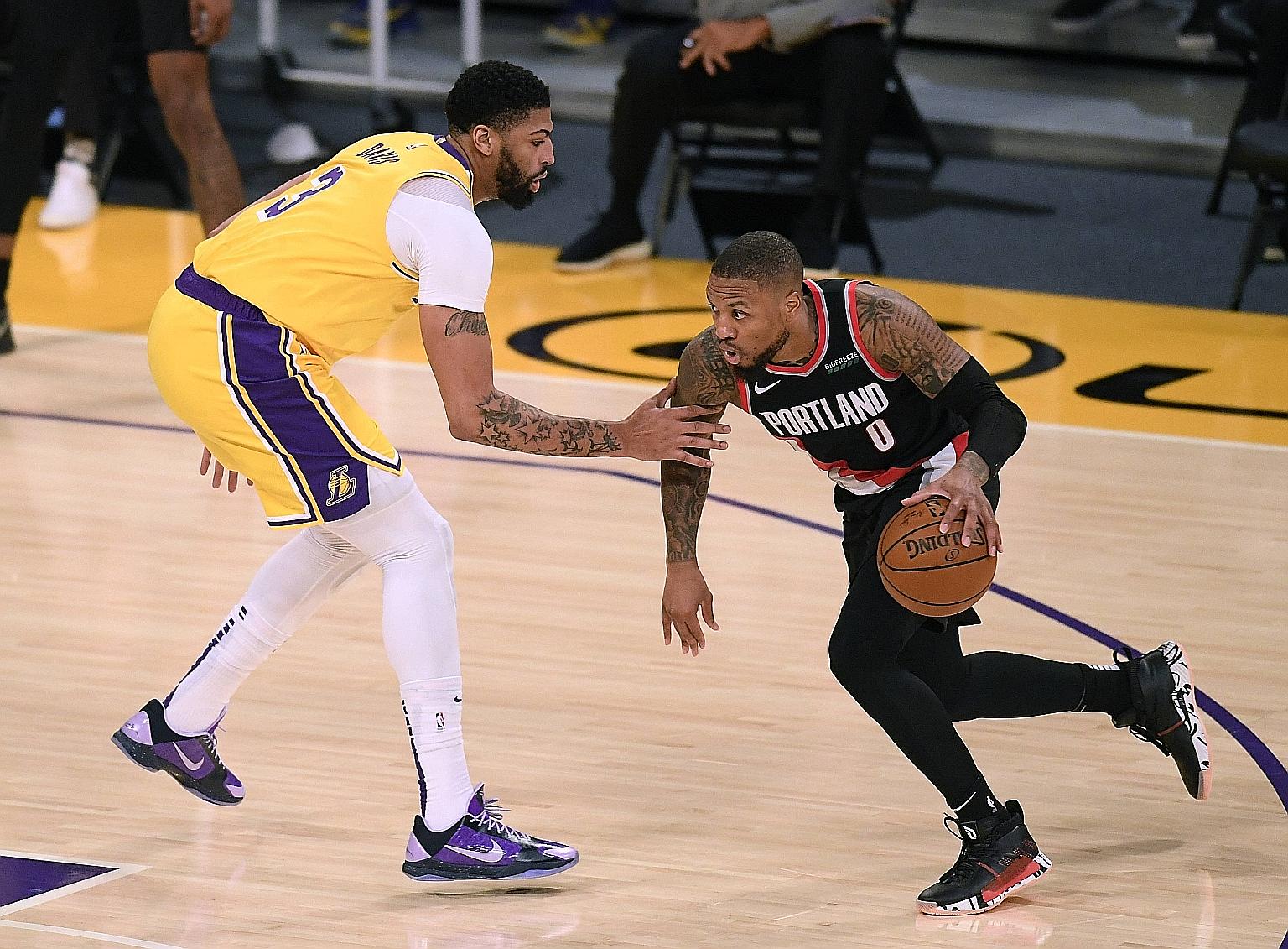 Portland guard Damian Lillard, facing Lakers' Anthony Davis, scored 31 points in the win over the NBA champions on Monday.