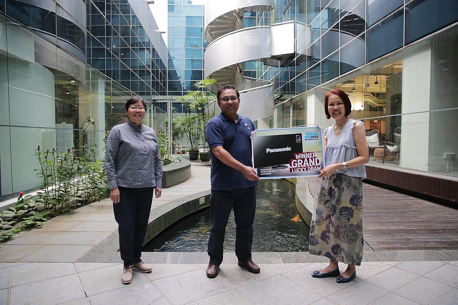 From left: Lee Yulin, ST sports editor and chairman of the STVR organising committee, Mohammad Zubayar Anis and Joanne Ng, general manager of Panasonic Singapore, posing for a photo yesterday after Zubayar won the grand lucky draw prize of a Panasoni