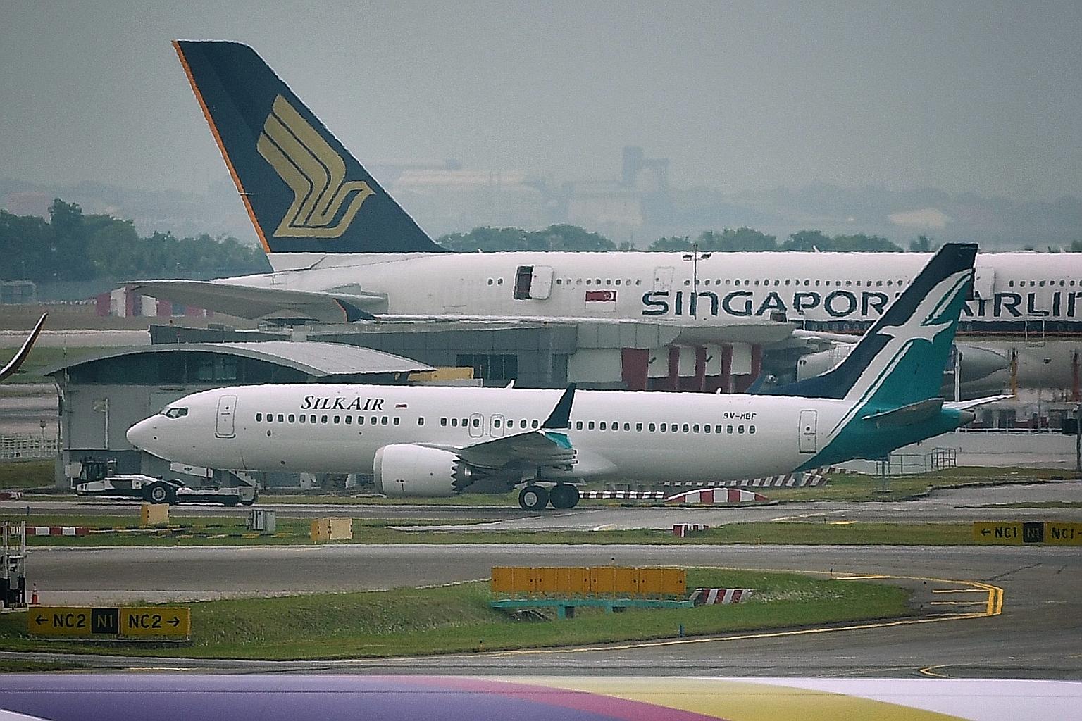 A SilkAir Boeing 737 Max plane (foreground) sitting on the tarmac at Changi Airport in March last year, when the Boeing aircraft model was grounded after two fatal accidents in five months. SIA told The Straits Times yesterday that it has received ap