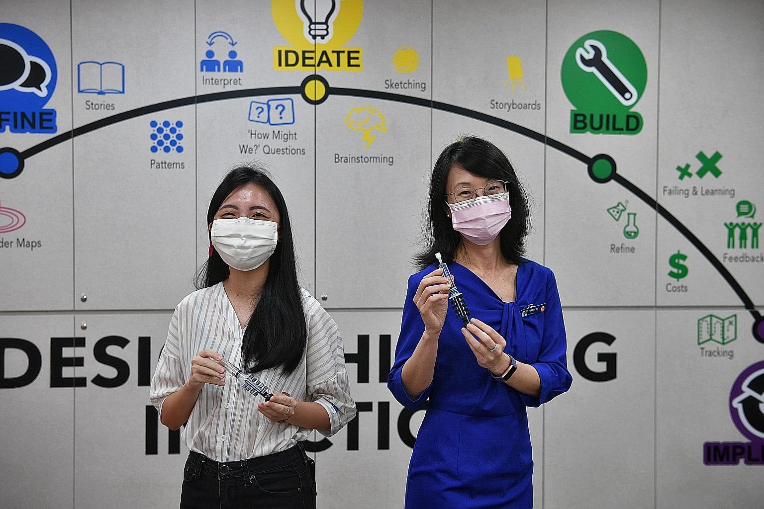 Changi General Hospital's senior principal pharmacist Yasmin Ng (in blue) and Ms Felicia Soon with the device they developed.