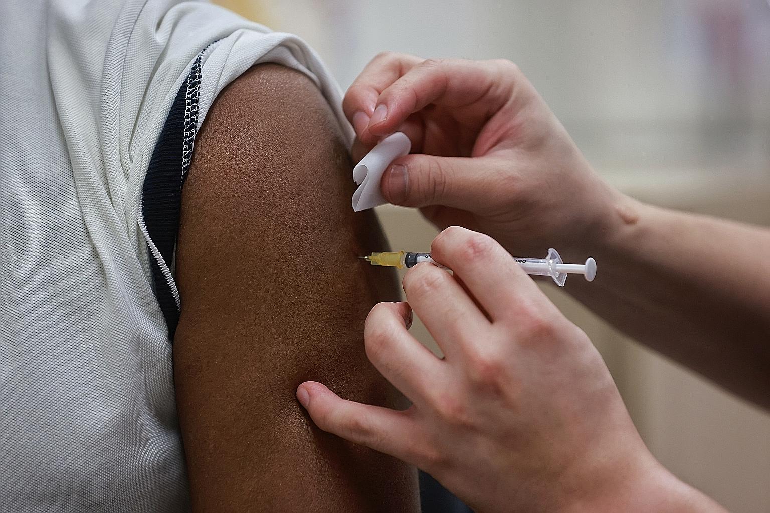 A National Centre for Infectious Diseases staff member receiving the Covid-19 vaccination last week. Health Minister Gan Kim Yong detailed in Parliament the rigorous review process that Covid-19 vaccines have to undergo before being approved for use 