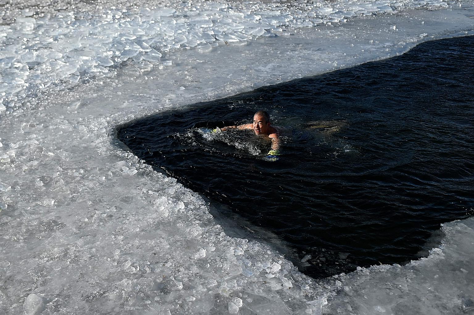 A swimmer braving the icy waters of a frozen lake in Beijing yesterday. The Chinese capital has been experiencing an unusually cold spell.