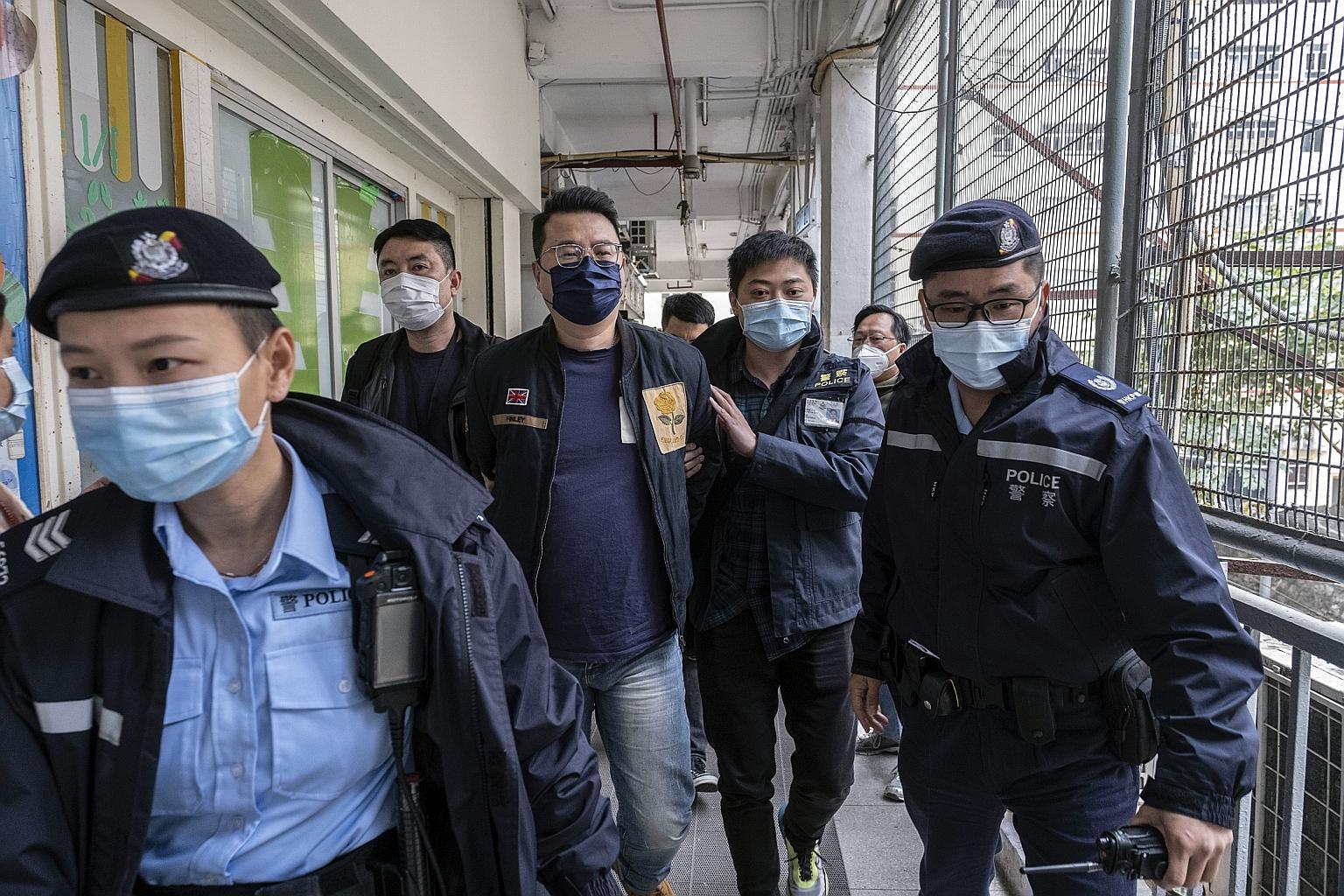 Former pro-democracy lawmaker Andrew Wan being escorted by police officers in Hong Kong on Wednesday, after he was detained on charges of subversion along with 52 other prominent figures, including a US citizen. The security sweep was the latest salv