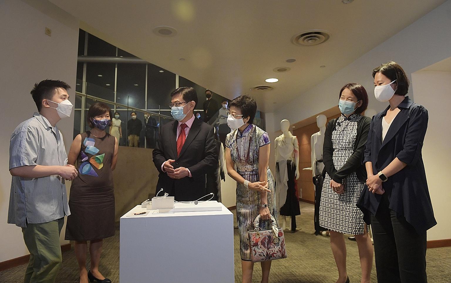 Nanyang Academy of Fine Arts (Nafa) graduate Chen Jiaqi (left) talking to Deputy Prime Minister Heng Swee Keat about his work, a jewellery collection, at the launch of the partnership yesterday. Mr Heng is flanked by Nafa president Tan-Soh Wai Lan (s