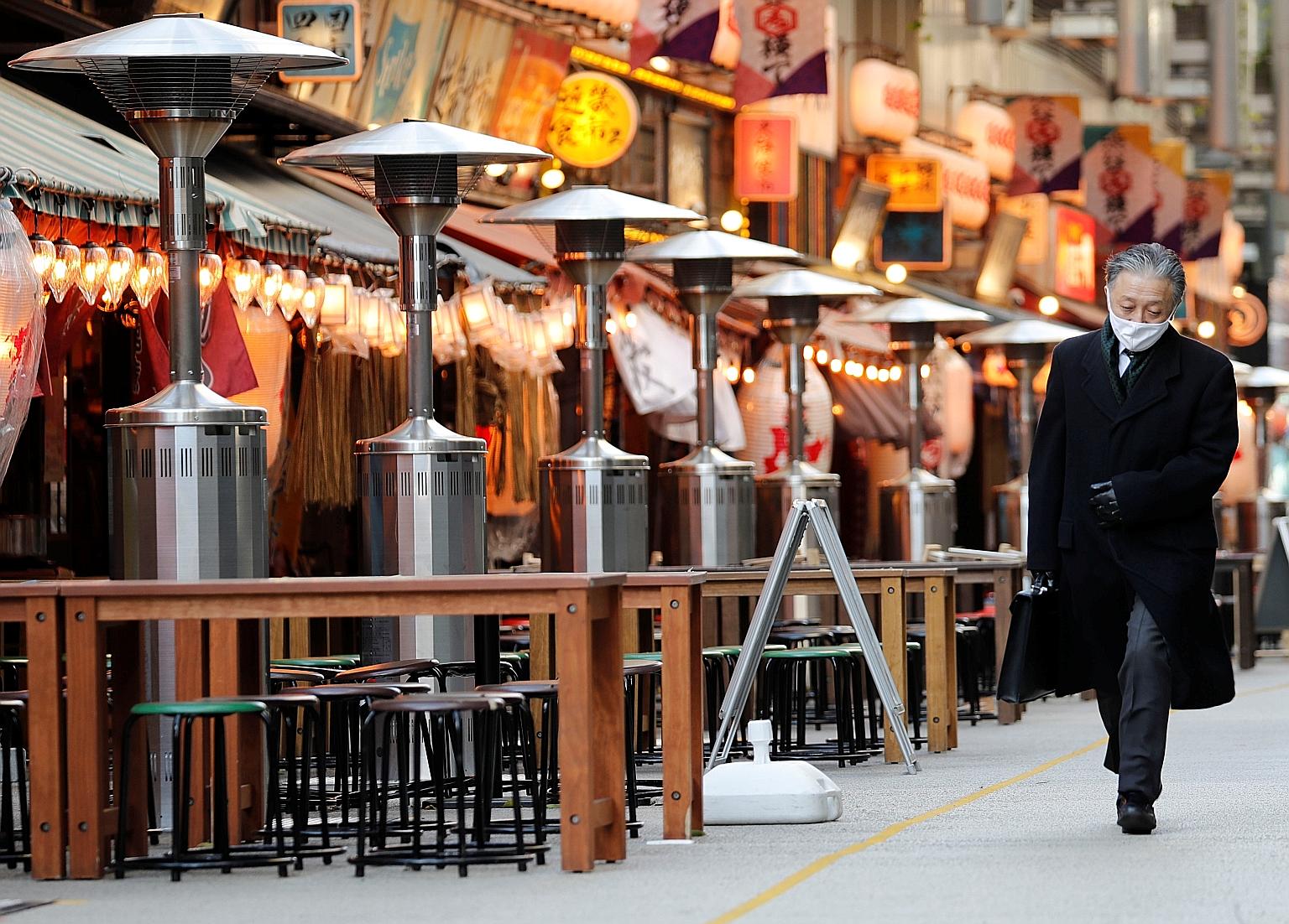 Empty tables at an eatery in Tokyo yesterday as the Japanese capital set a new one-day high of 2,447 fresh coronavirus cases. An emergency decree declared in the city and its three neighbouring prefectures targets restaurants and bars by asking them