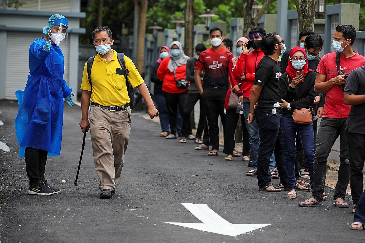 People queueing to get tested for Covid-19 in Shah Alam, Selangor, yesterday. Malaysia has announced that government schools will reopen as scheduled on Jan 20, despite new coronavirus infections staying stubbornly high. The number of daily cases in 