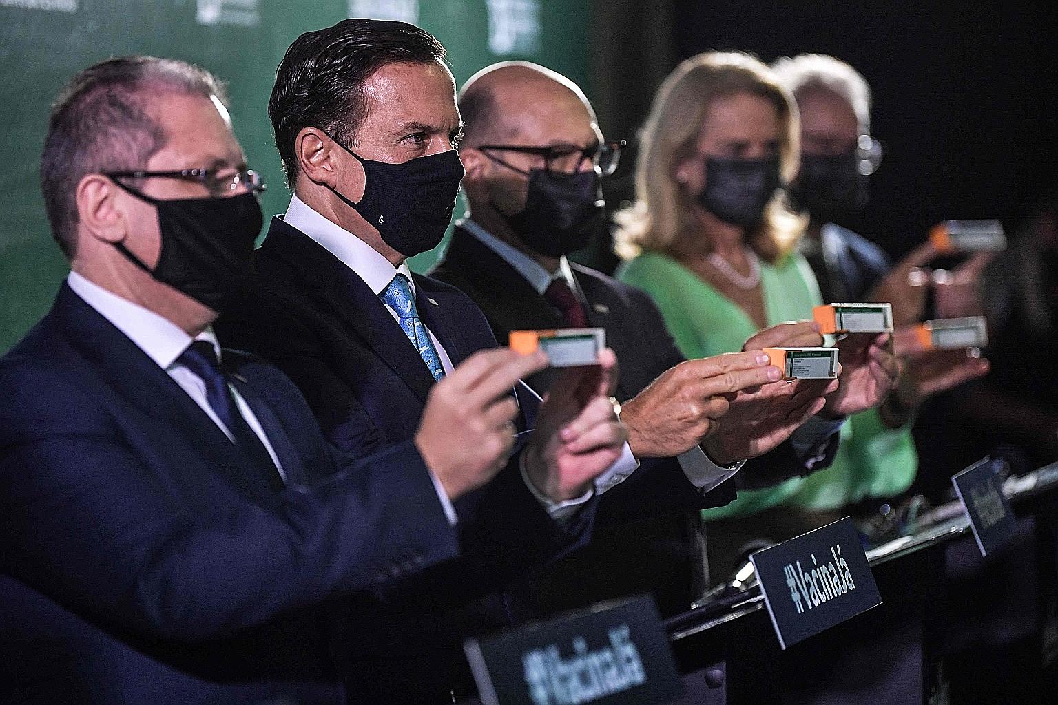 Sao Paulo Governor Joao Doria (second from left) showing the CoronaVac vaccine to the media at biomedical centre Butantan's headquarters in the Brazilian state on Thursday. Butantan is the research and production partner of China's Sinovac Biotech, w