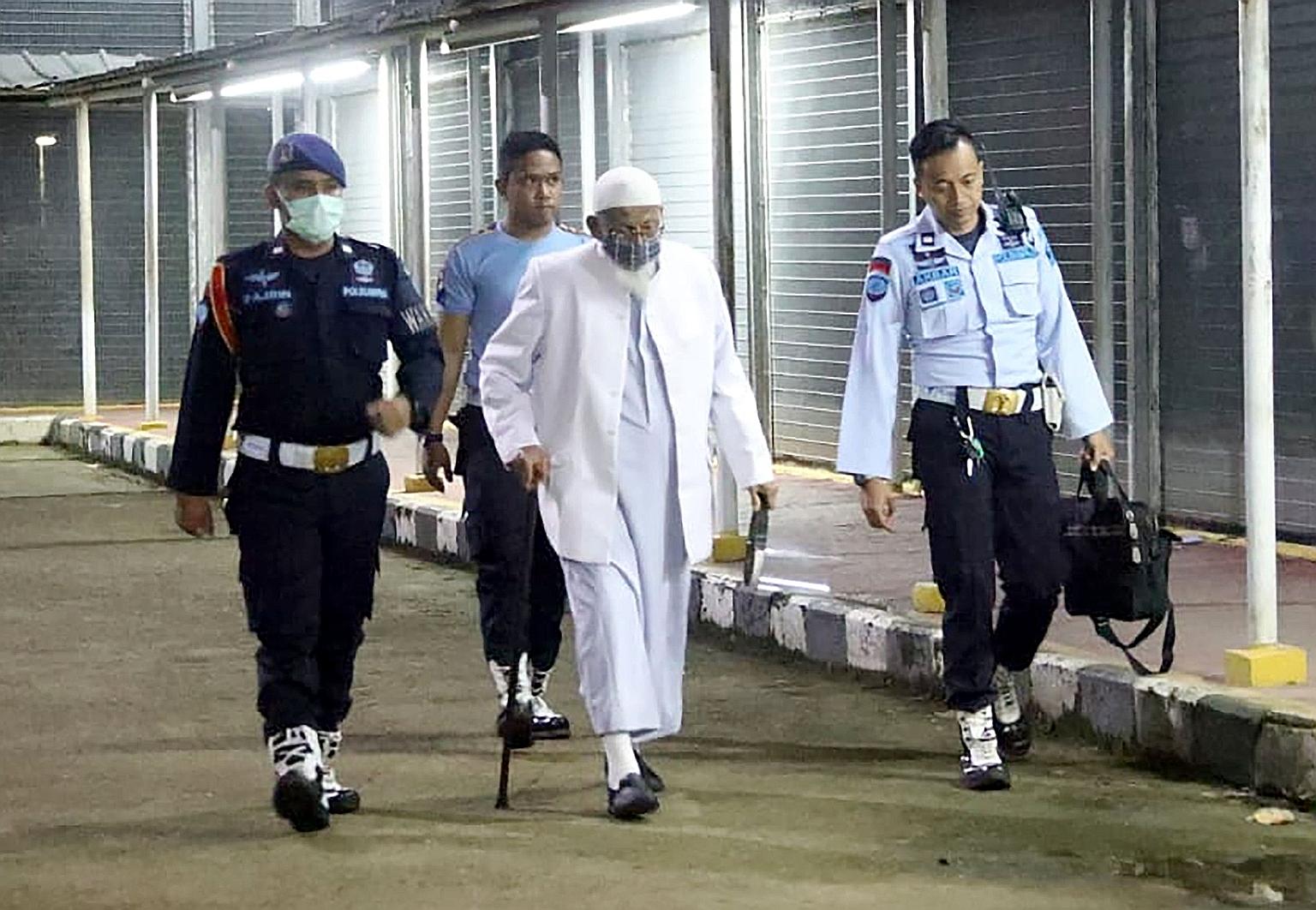 Mr Abu Bakar Bashir, 82, the spiritual leader of South-east Asia's terrorist group Jemaah Islamiah, being escorted out by prison guards yesterday as he left the Gunung Sindur prison in Bogor, on the outskirts of Jakarta. The radical cleric had been i