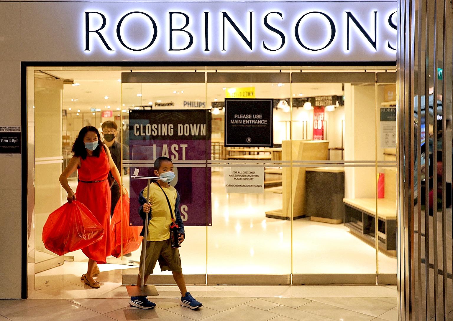 A woman, who wanted to be known only as Ms Zheng, 45, and her son were the last customers to leave Robinsons' outlet at Raffles City at 3.57pm yesterday, its last day of operation. ST PHOTO: JOEL CHAN