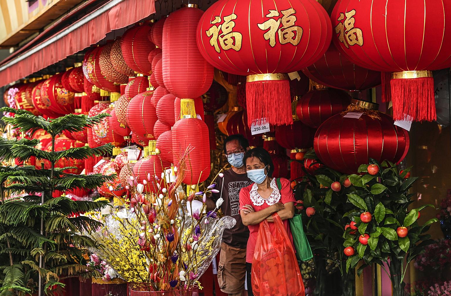People shopping for festive decorations in Kuala Lumpur last Friday. Major Chinese groups in Malaysia have implored those celebrating Chinese New Year to restrict visits and gatherings, amid the high number of daily Covid-19 cases.