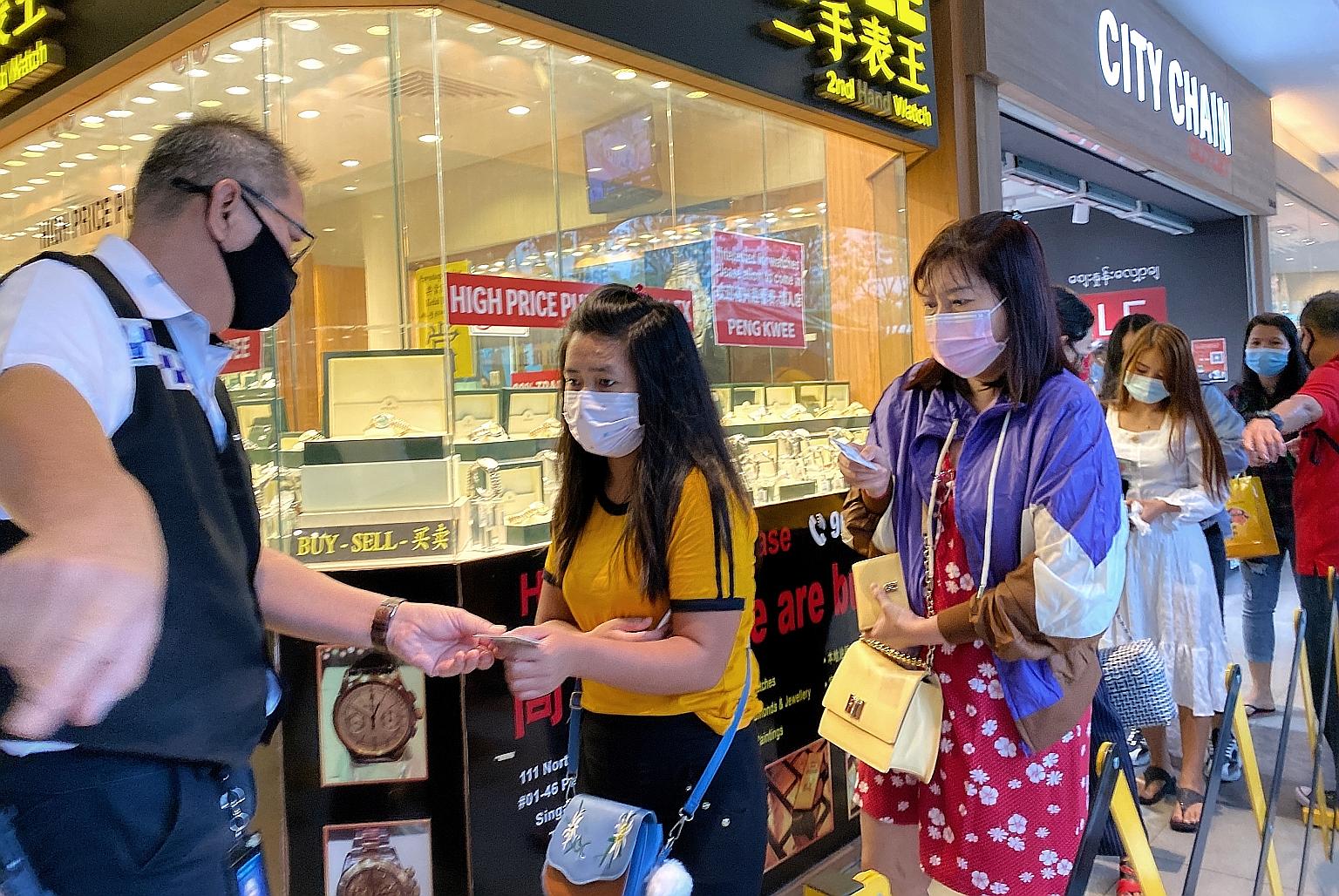 Left: A woman being turned away outside Peninsula Plaza, which has an odd-even weekend entry system for crowd control, yesterday. ST PHOTO: GAVIN FOO