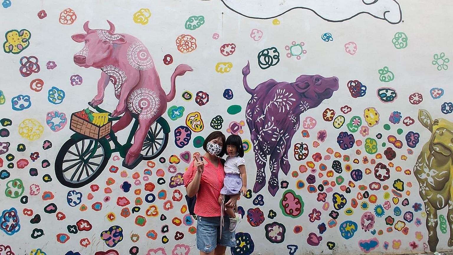 Housewife Low Fang Ting, 34, with one of her three children, Ashley, two, posing in front of a Little India mural. Ms Low has been bringing her three children out on tours to learn more about the city's unique precincts.