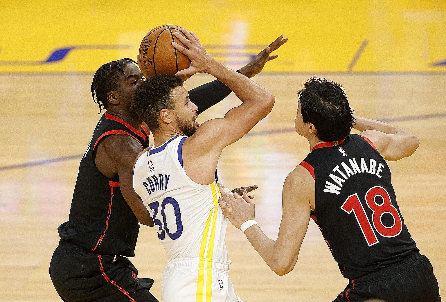 Golden State's Stephen Curry being guarded by Toronto's Terence Davis and Yuta Watanabe in Sunday's NBA game in San Francisco. The home team squeaked through 106-105 despite Curry's paltry 11-point contribution.