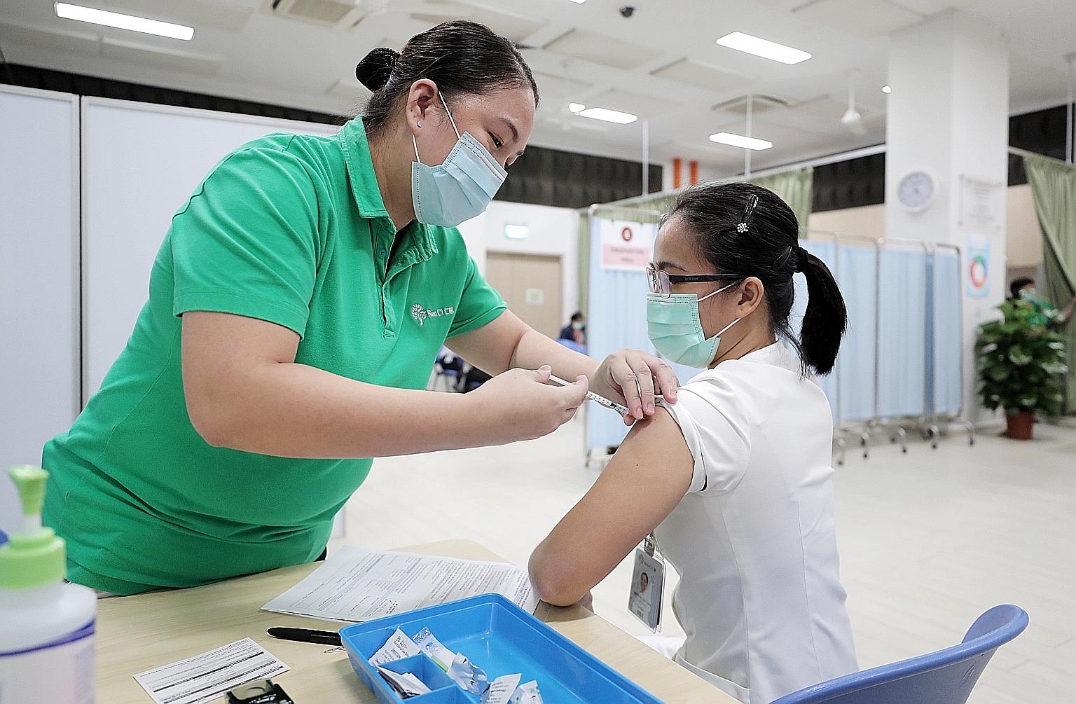An employee at Ren Ci @ Bukit Batok Street 52 receiving the Pfizer-BioNTech Covid-19 vaccine yesterday. Fifty staff at the nursing home received the jab, and the other 110 or so employees will be vaccinated in two batches over the next two weeks.