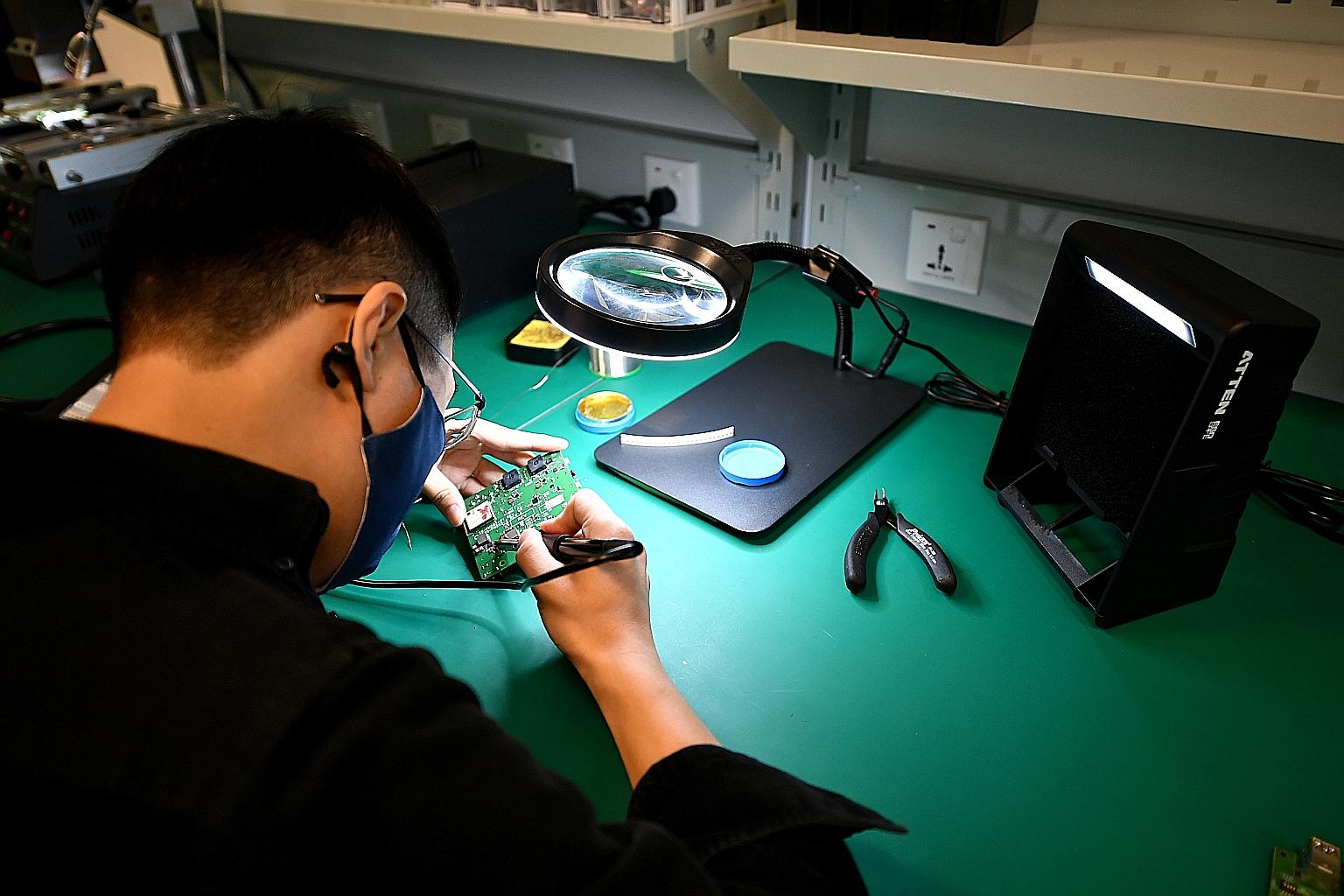 PlanetSpark senior engineer Zhou Xiang, 32, debugging hardware in a test lab at PlanetSpark Innovation Centre's launch yesterday.